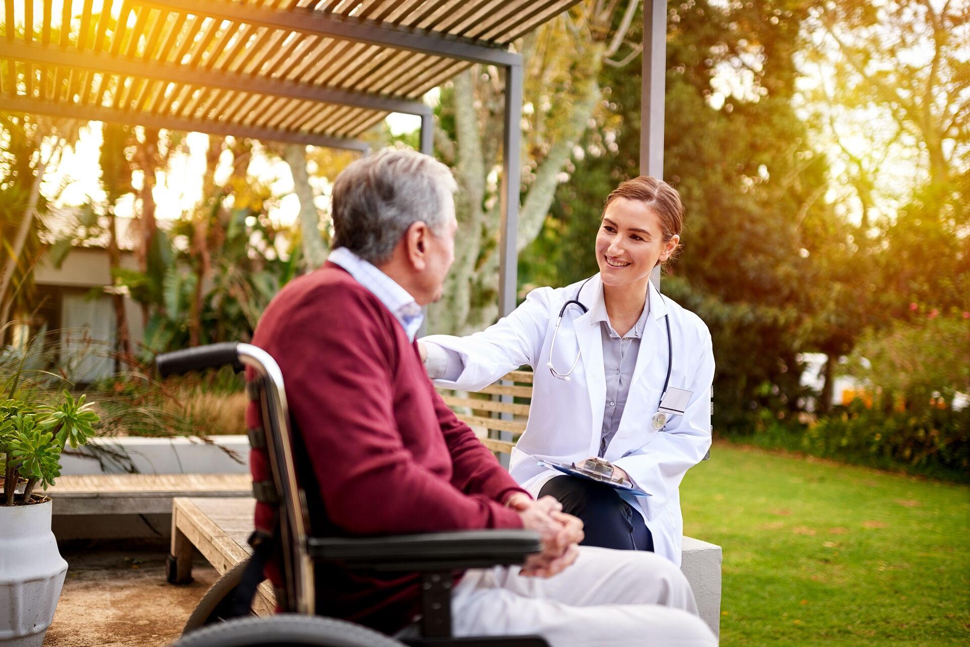 senior man in a wheelchair talking with a caregiver