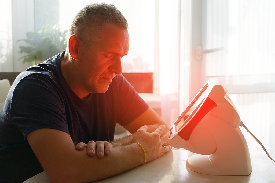 Man using red light therapy on his face