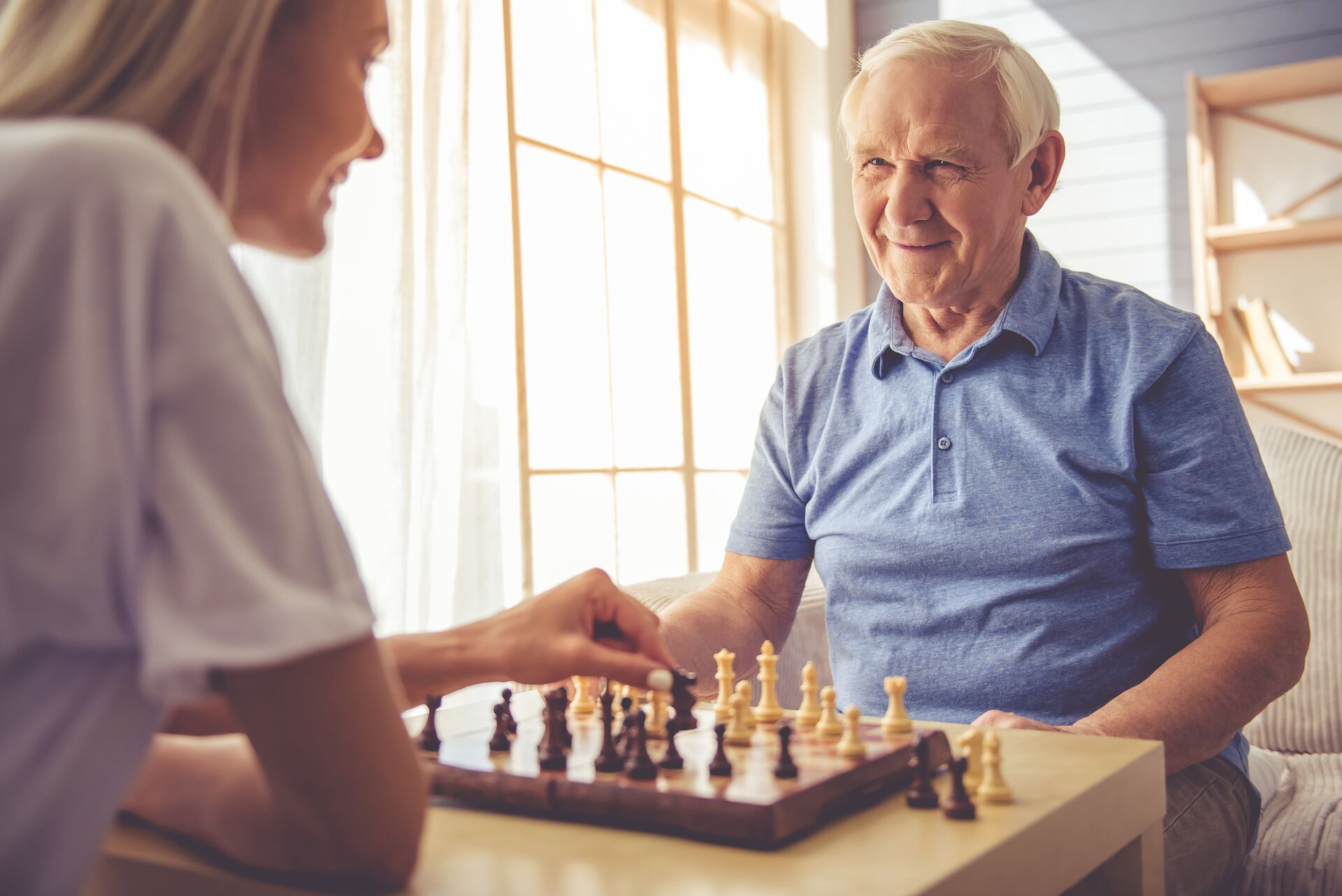 Nurse playing chess with senior man