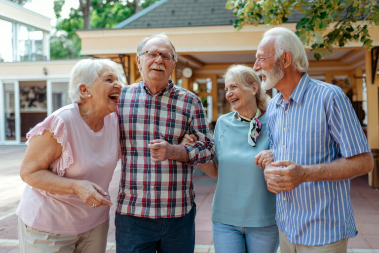 Cheerful Senior Friends Enjoying Afternoon Together. Group of Four Mature People Outside Laughing. Happy Senior Man and Old Woman Enjoying Together