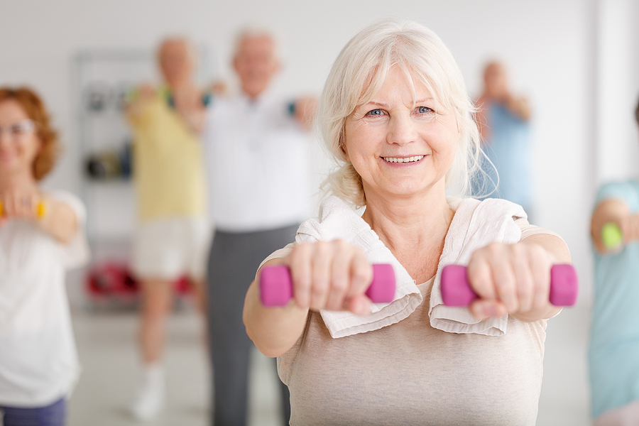 Older woman exercising happily in the gym
