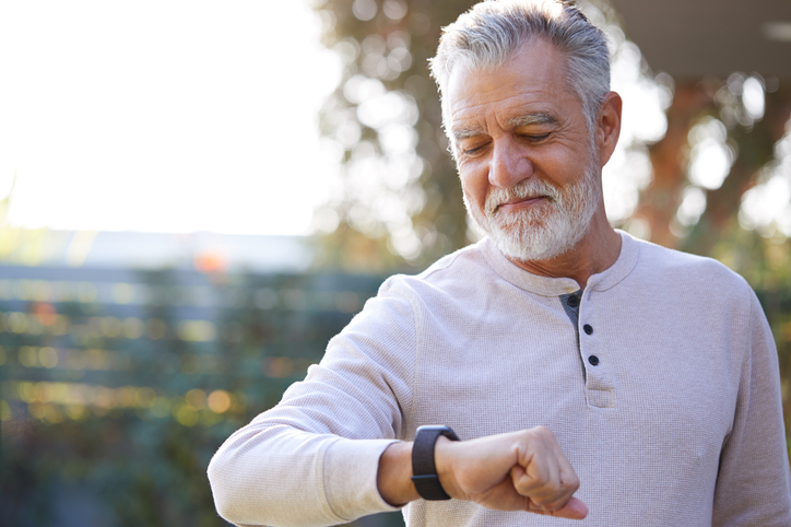 A senior man using wearable technology to track health