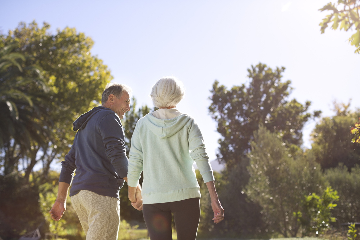 A senior couple holding hands walking together