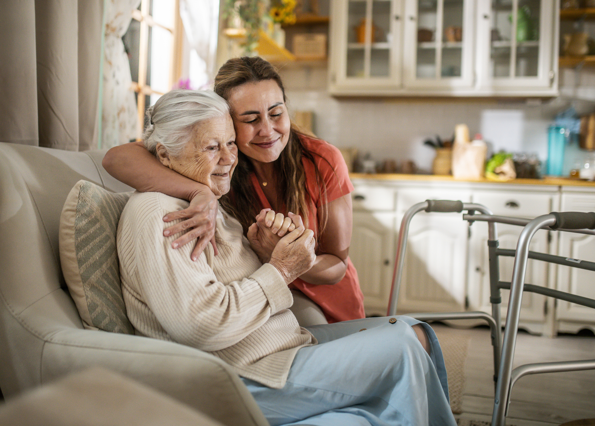 A daughter hugs her elderly mother at her assisted living apartment